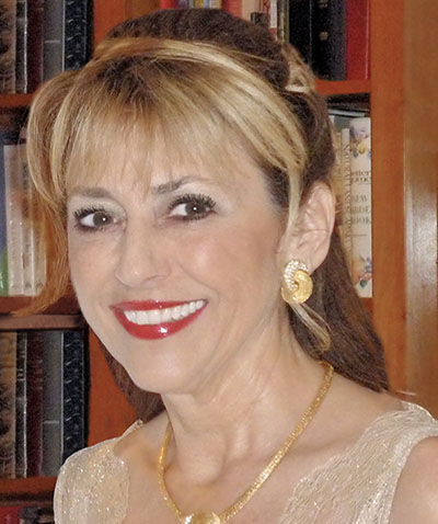 Smiling woman with earrings and necklace.